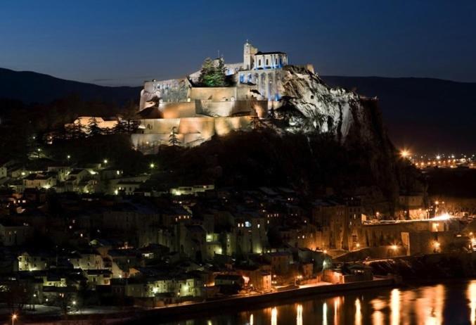 un castillo en la cima de una montaña por la noche en Etxe Laminak en Sisteron