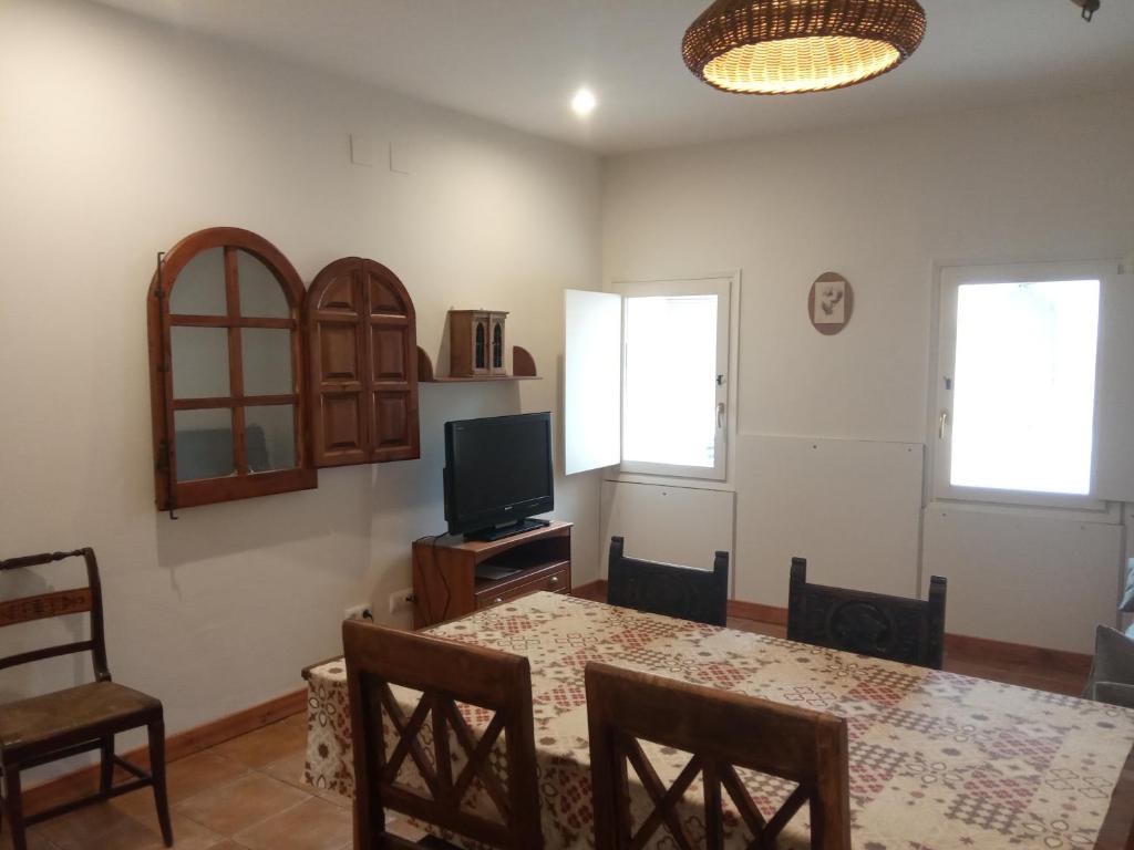 a dining room with a table and a television at El Olivo in Torre del Compte