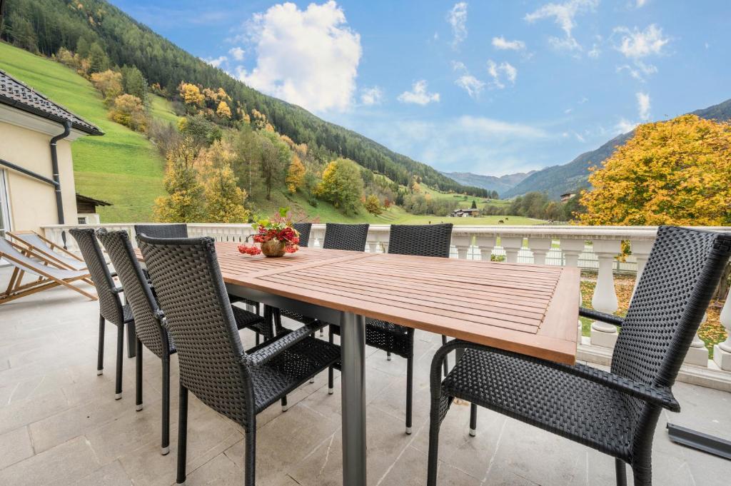 a wooden table and chairs on a patio with a view at Alpen Living - 1 Stock Ganz in Cadipietra