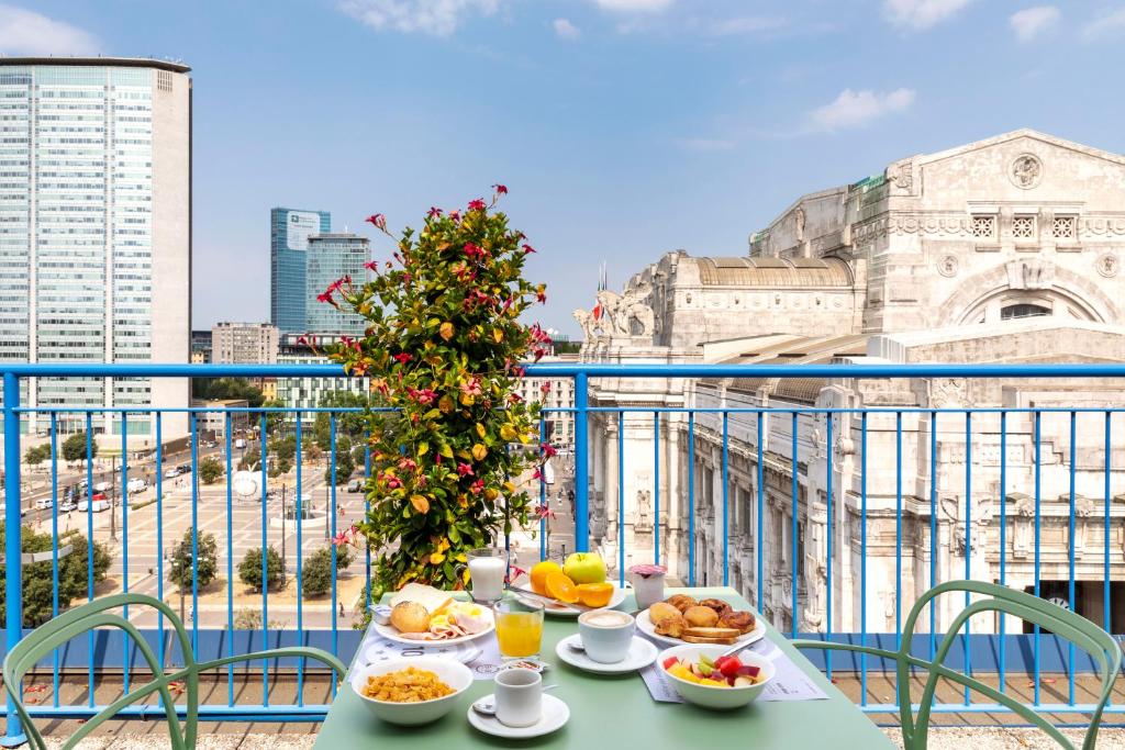 een tafel met borden eten op een balkon bij B&B Hotel Milano Aosta in Milaan