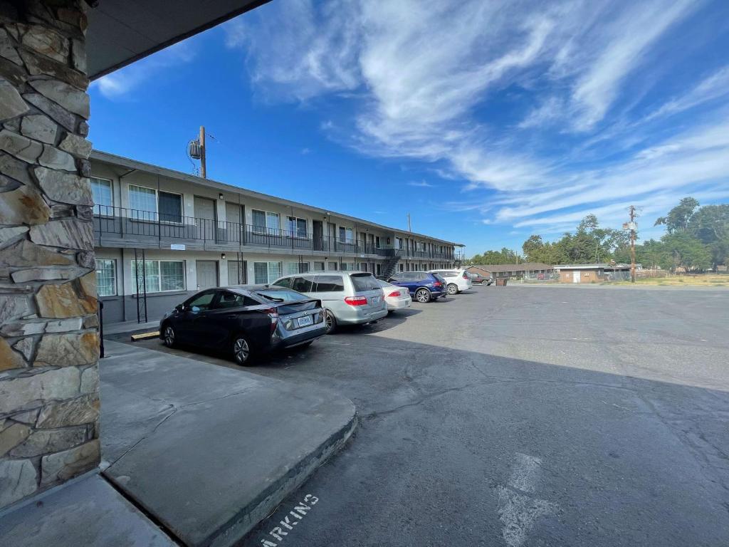 a parking lot with cars parked in front of a building at Motel 6 Hermiston OR Umatilla in Hermiston