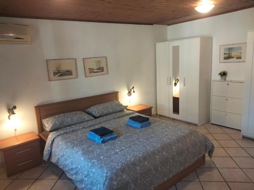 een slaapkamer met een bed met twee blauwe dozen erop bij ZÍ MARIO Suite degli Ospiti - Roma Ostia Antica in Ostia Antica