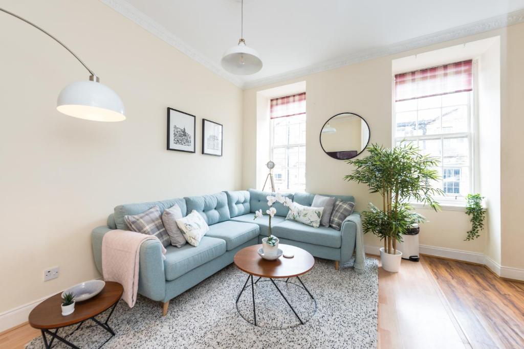 - un salon avec un canapé bleu et une table dans l'établissement Bright and modern 2 bed apartment, à Édimbourg