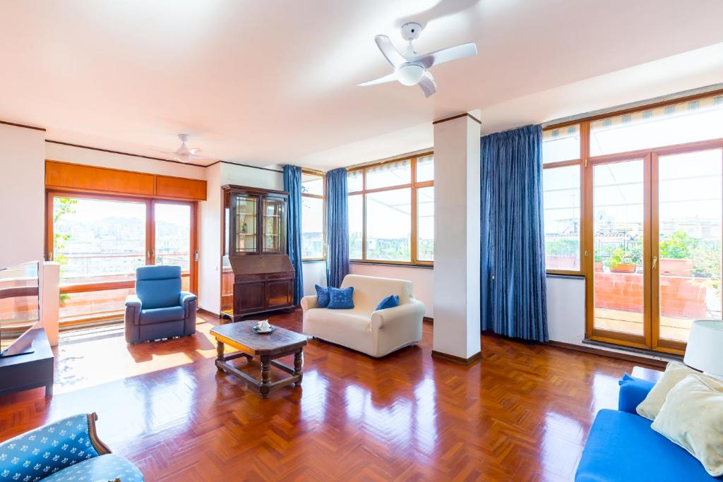 Terrazza 30 by Napoliapartments في نابولي: غرفة معيشة مع أثاث أزرق ونوافذ كبيرة