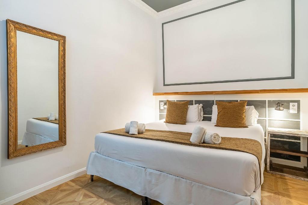 a bedroom with a large bed with a mirror at Casa Gracia Apartments in Barcelona