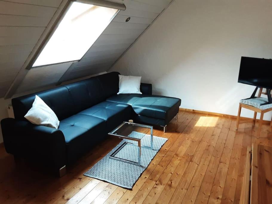 a living room with a blue couch and a window at Bruno's Ferienwohnung in Gerolzhofen in Gerolzhofen