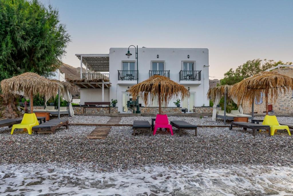 un complexe avec des chaises et des parasols colorés sur la plage dans l'établissement Uno Apartment 1st Floor, à Livadia