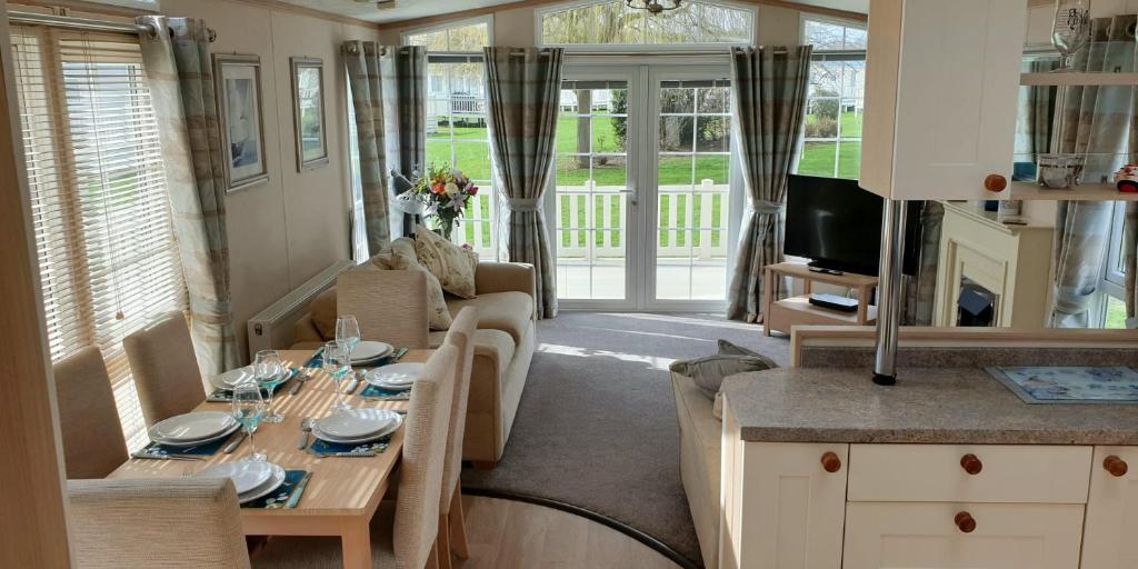 a living room with a couch and a table with chairs at Willow Lodge in South Cerney