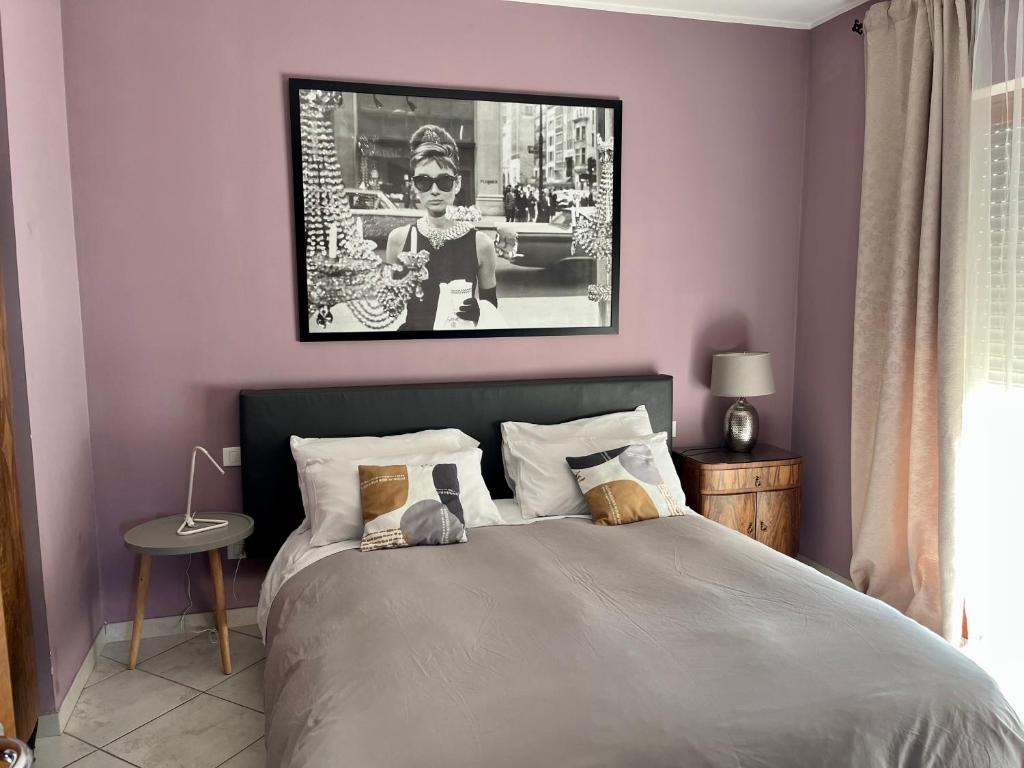 a bedroom with a bed with a picture on the wall at Via Roma suite in Ortona