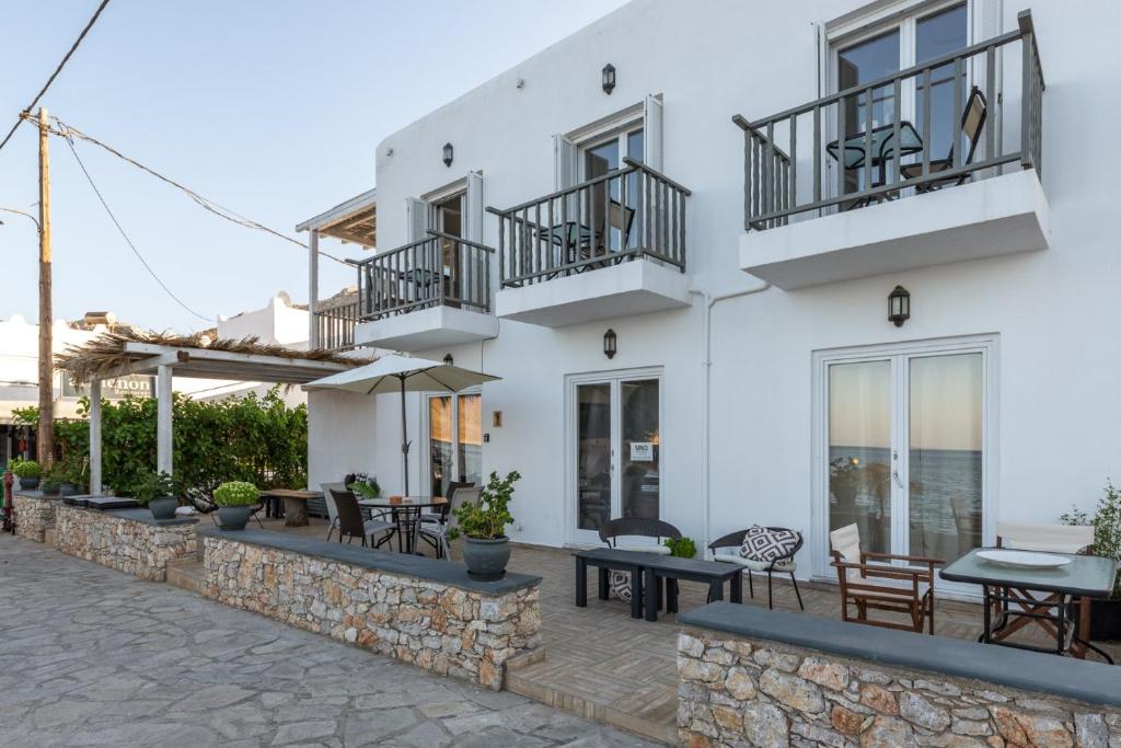 a white building with tables and chairs in front of it at Uno Apartment 2 in Livadia