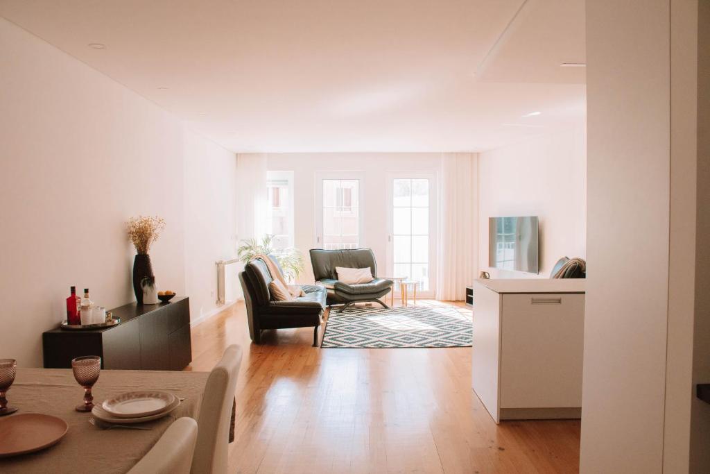 een witte woonkamer met een tafel en stoelen bij Just Like Home - Casinhas da Vila T2 em Caminha in Caminha