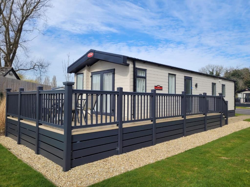 a house with a fence in front of it at Primrose - 3 bedroom luxury lodge in South Cerney