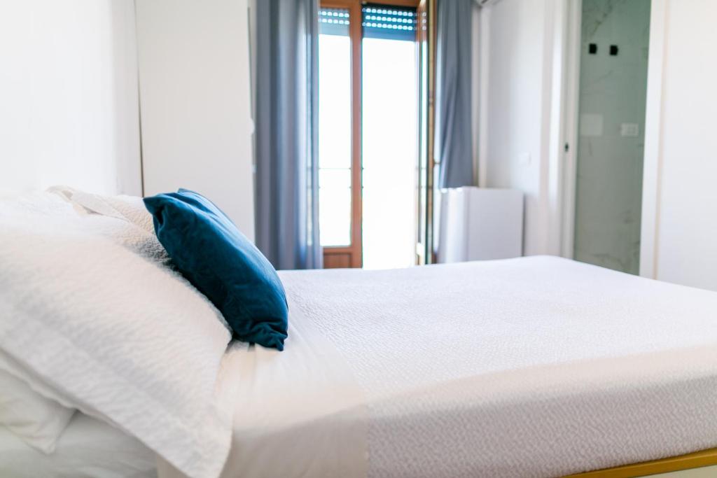 a bed with a blue pillow on top of it at B&B Best Hostel Milano in Milan