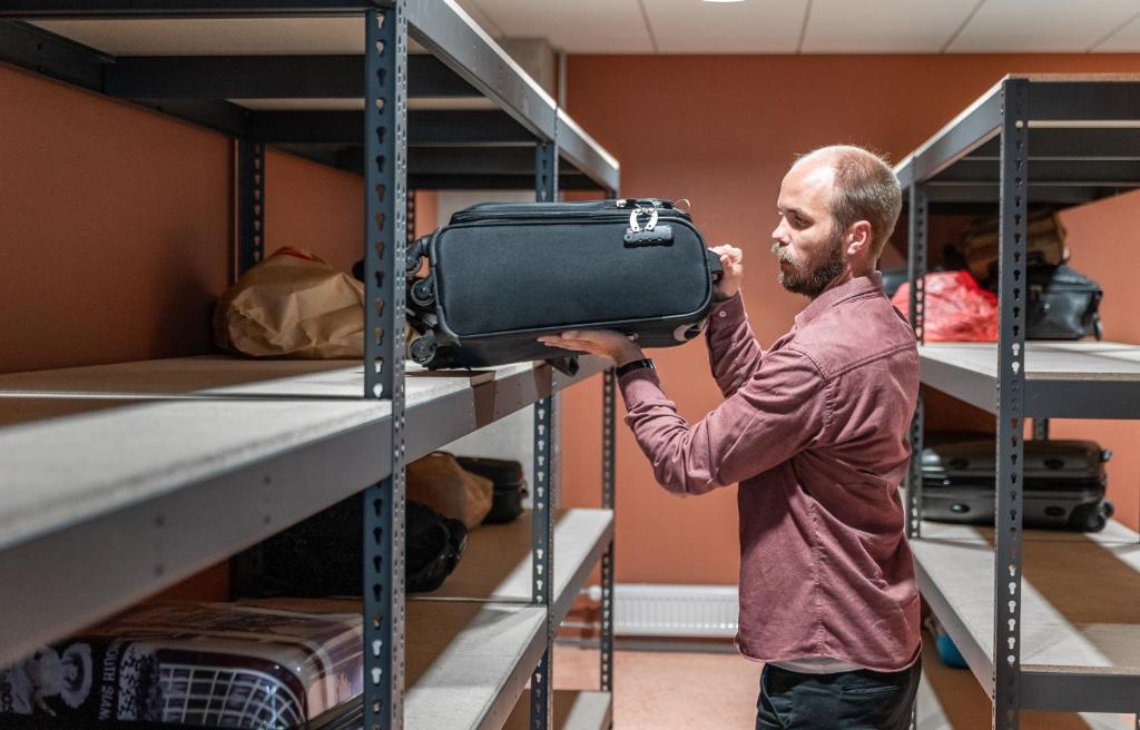 a man is holding a suitcase on a shelf at Citybox Oslo in Oslo