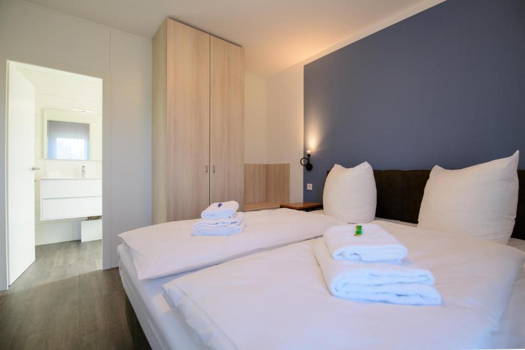 a bedroom with two beds with towels on them at Smart & Stay Aparthotel Saarbrücken Süd - Self-Check-In - Free Parking in Saarbrücken