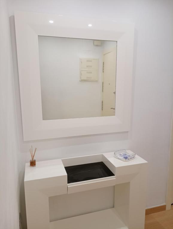 un bagno bianco con specchio e lavandino di El piset de la font a Onda
