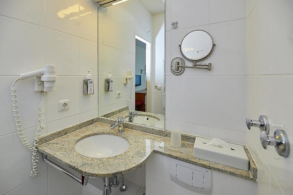 a bathroom with a sink and a mirror at Hotel Diamant in Wedel