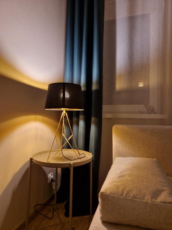 una lámpara sentada en una mesa junto a una cama en 91WrocLove Apartaments, en Wroclaw