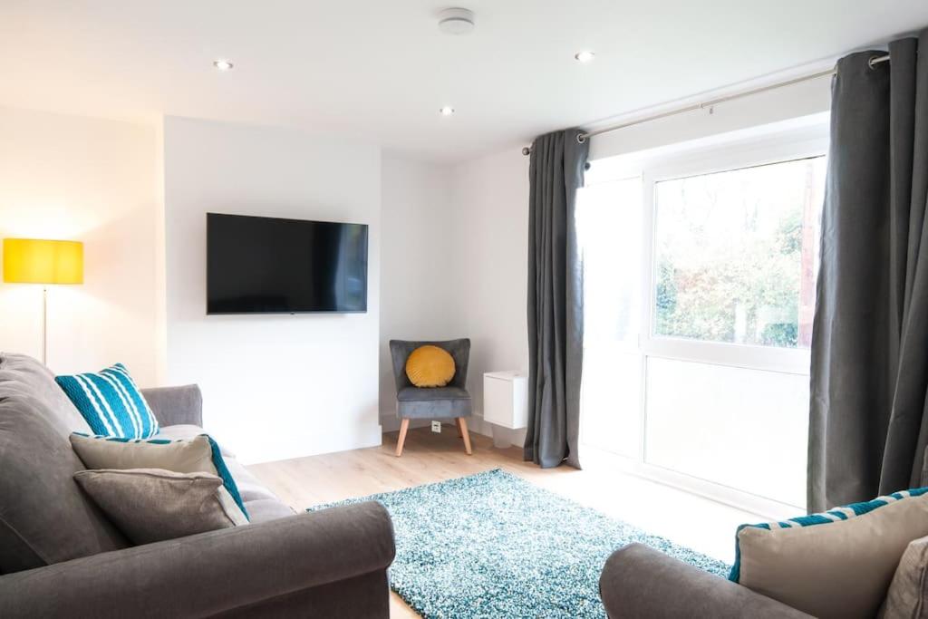 a living room with a couch and a tv at The Spitfire - Renovated 3-bed house in Cheltenham, SLEEPS 8 in Cheltenham