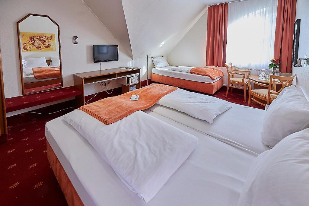 a hotel room with two beds and a mirror at Hotel Diamant in Wedel