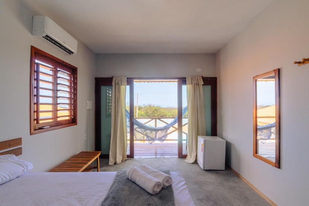 a bedroom with a bed and a balcony at Villa Ondas in Barra Grande