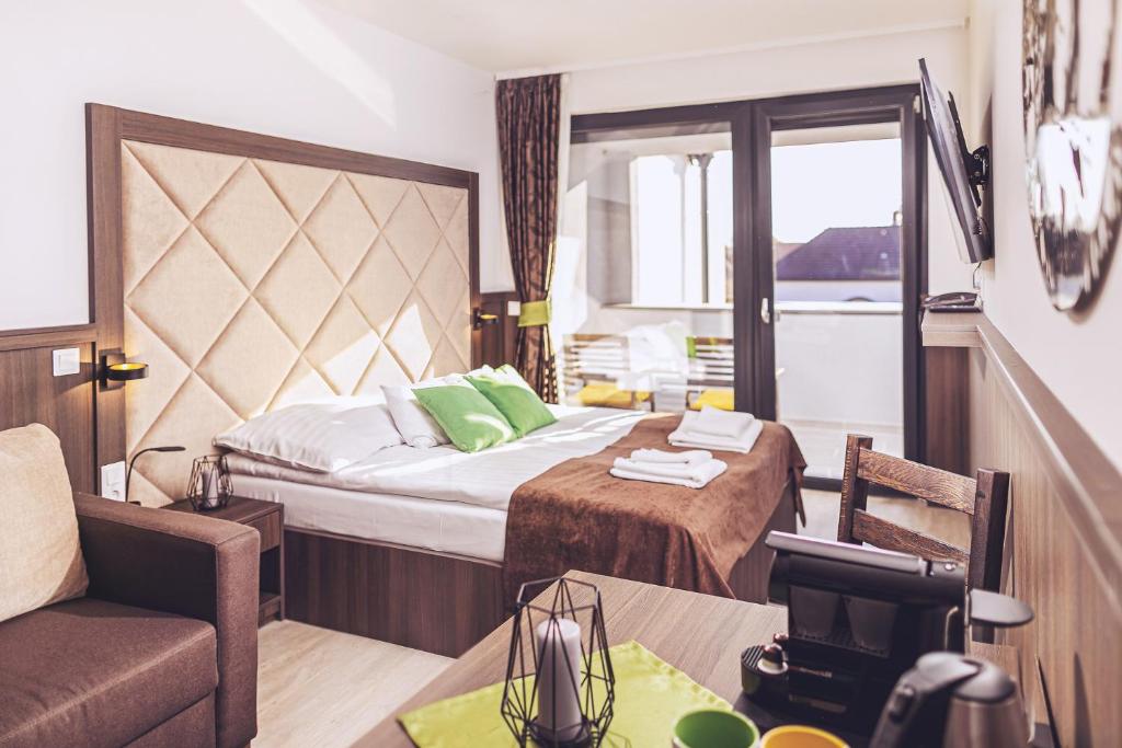 um quarto de hotel com uma cama, uma cadeira e uma mesa em Park Hotel Bük-Bükfürdő em Bük