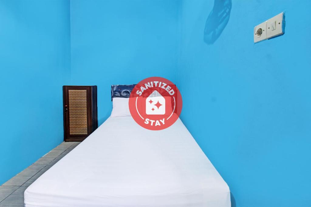 Una cama con un cartel encima. en SPOT ON 91811 Rumah Inap Bunda Nurhayati, en Praya