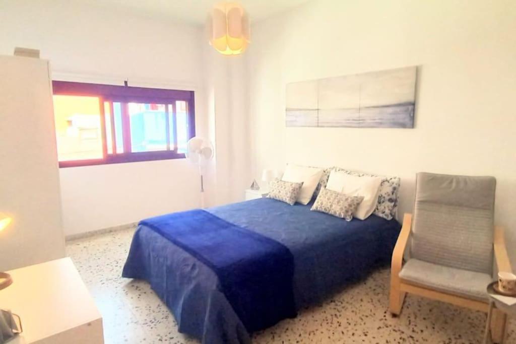 a bedroom with a blue bed and a chair at Habitación privada Dorive con baño privado in San Andrés