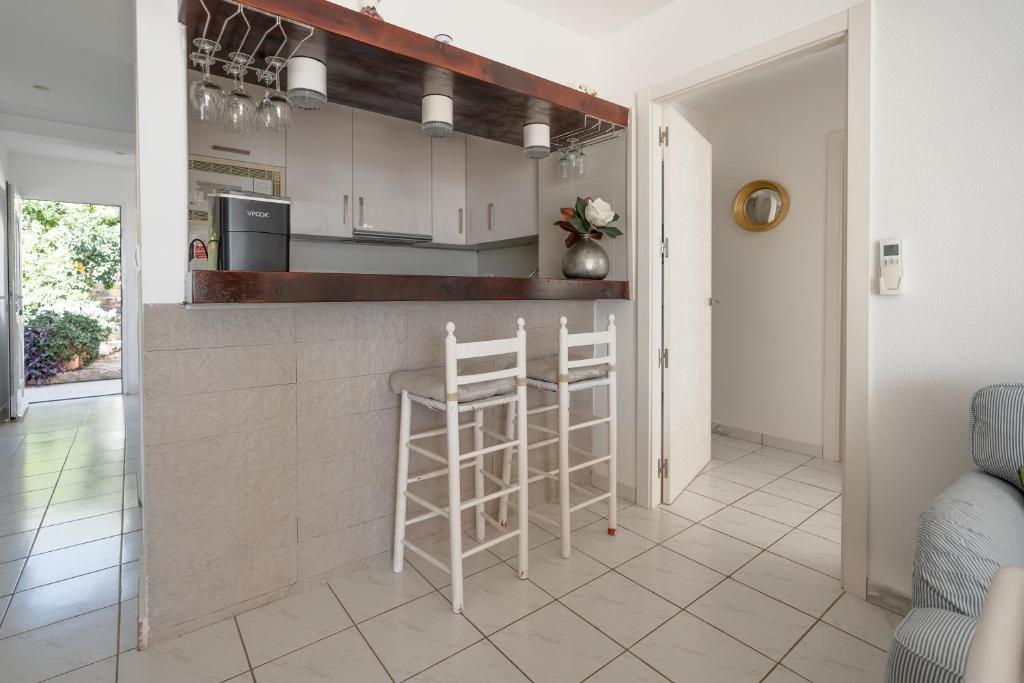 a kitchen with a counter and stools in a room at Maryvilla Inspiración y Vacaciones - Bungalows in Calpe