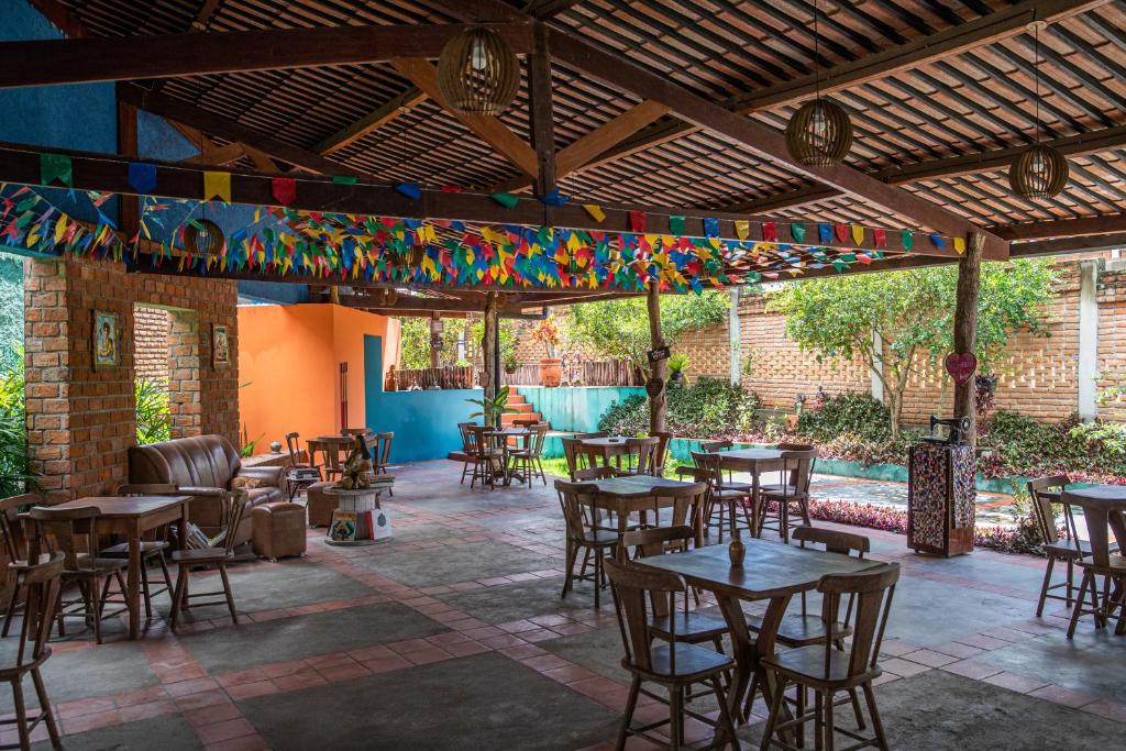 d'une terrasse avec des tables, des chaises et des drapeaux colorés. dans l'établissement JasmiManga Pousada, à Caruaru