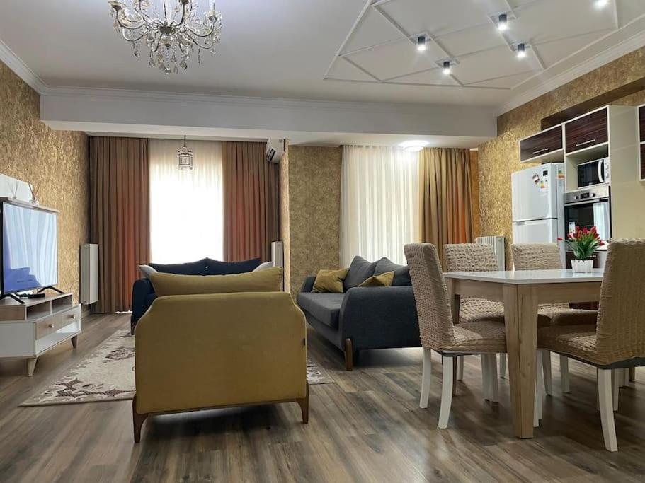 ein Wohnzimmer mit einem Sofa und einem Tisch in der Unterkunft Park Azure Modern apartment in Baku