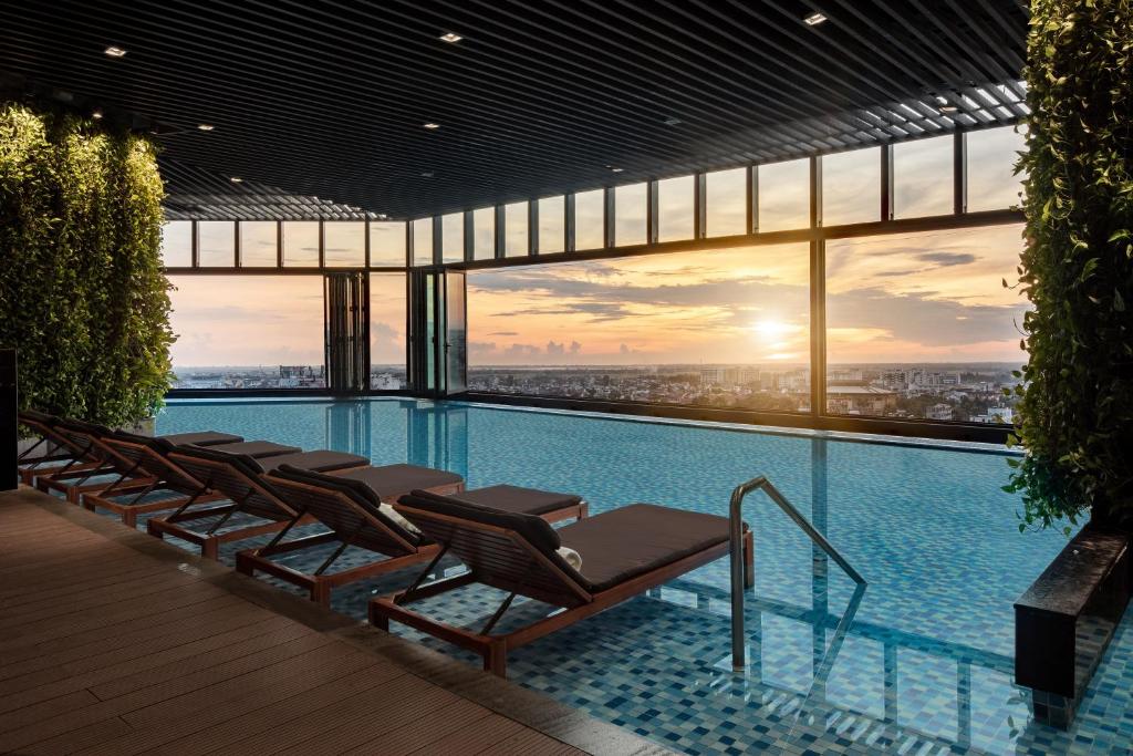 a pool with chairs and a view of a city at Melia Vinpearl Hue in Hue