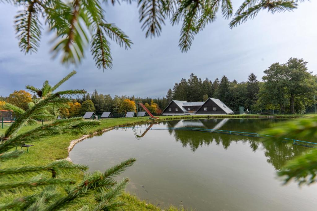 a view of a lake with houses and trees at Jasenka rekreační středisko Zubří in Nové Město na Moravě