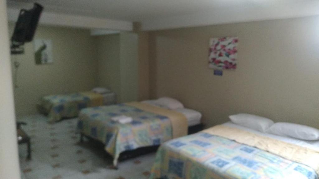 Postel nebo postele na pokoji v ubytování Hotel Queens