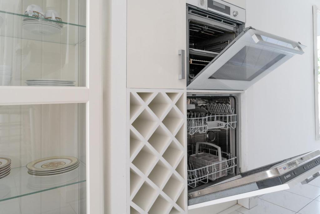 a dishwasher in a kitchen with white cabinets at Maryvilla Inspiración y Vacaciones - Bungalows in Calpe