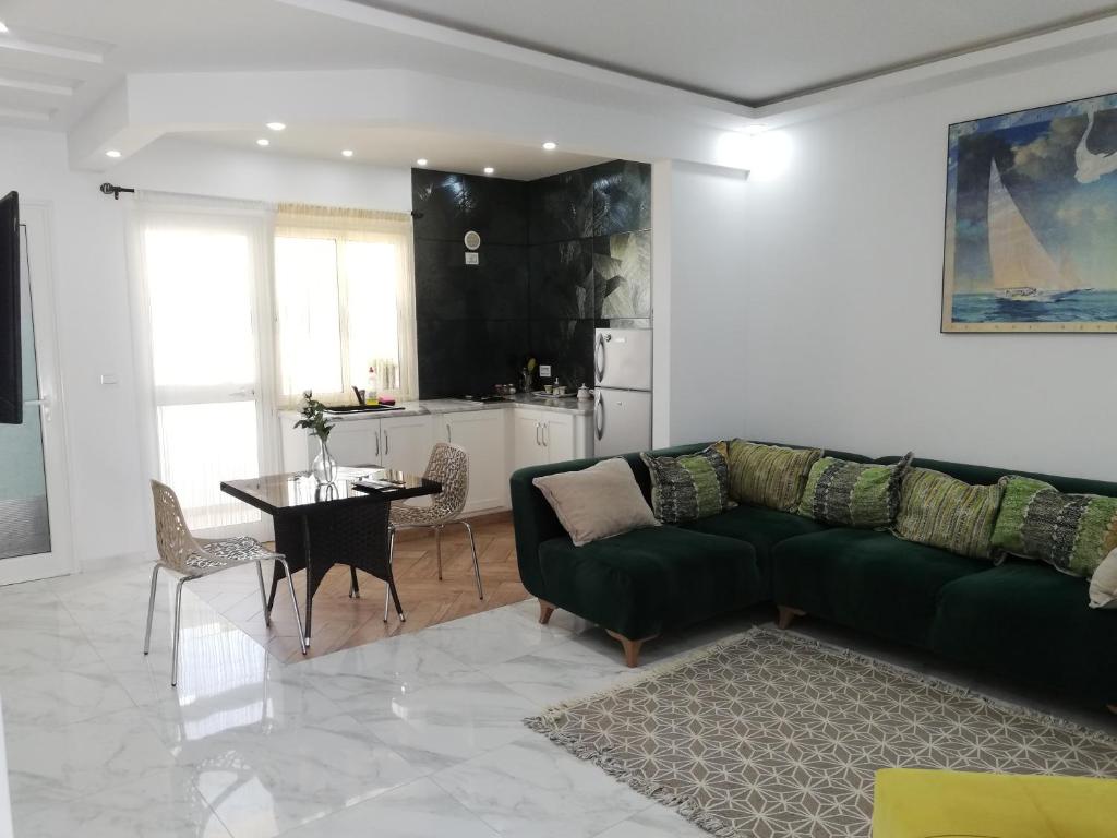 sala de estar con sofá verde y mesa en Residence Debbabi, en Monastir