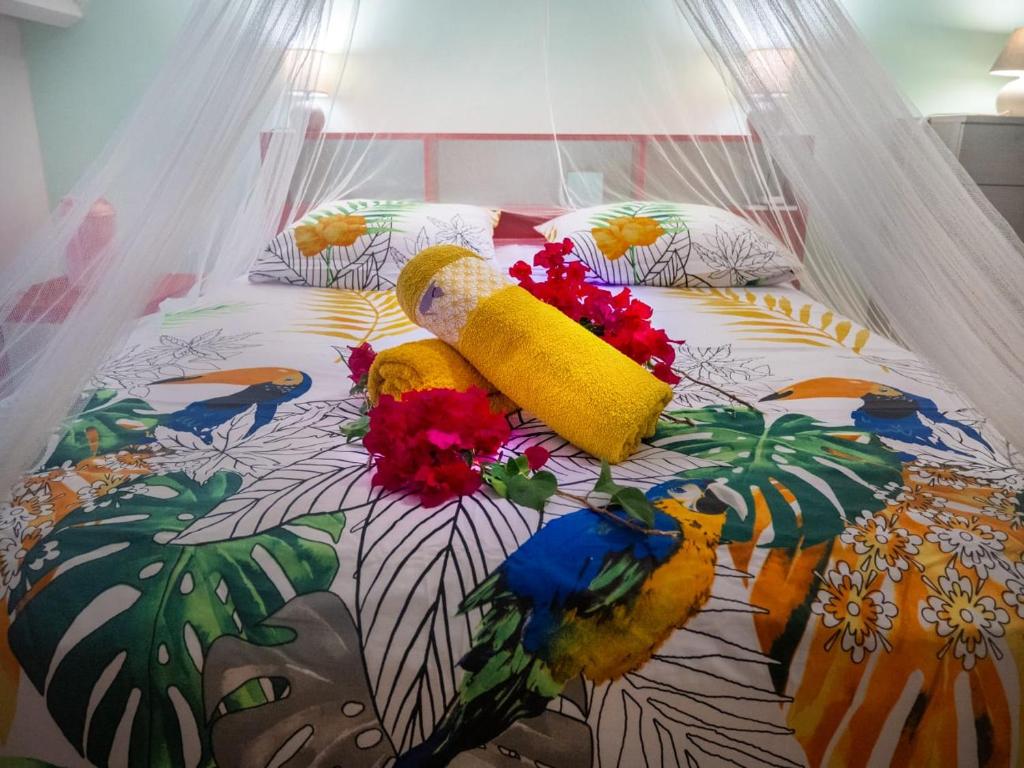 uma cama com flores em cima em Studio T1 bis La Belle Vue, vue mer, wifi, plage à 50m em Le Moule