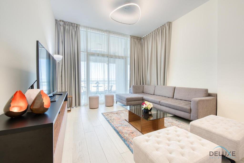 een woonkamer met een bank en een tafel bij Expansive 2BR at Azizi Aliyah Dubai Healthcare City by Deluxe Holiday Homes in Dubai