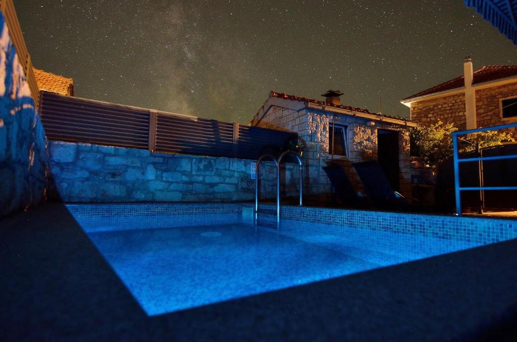 a house with a swimming pool at night at House Tihana in Donje Selo na Šolti