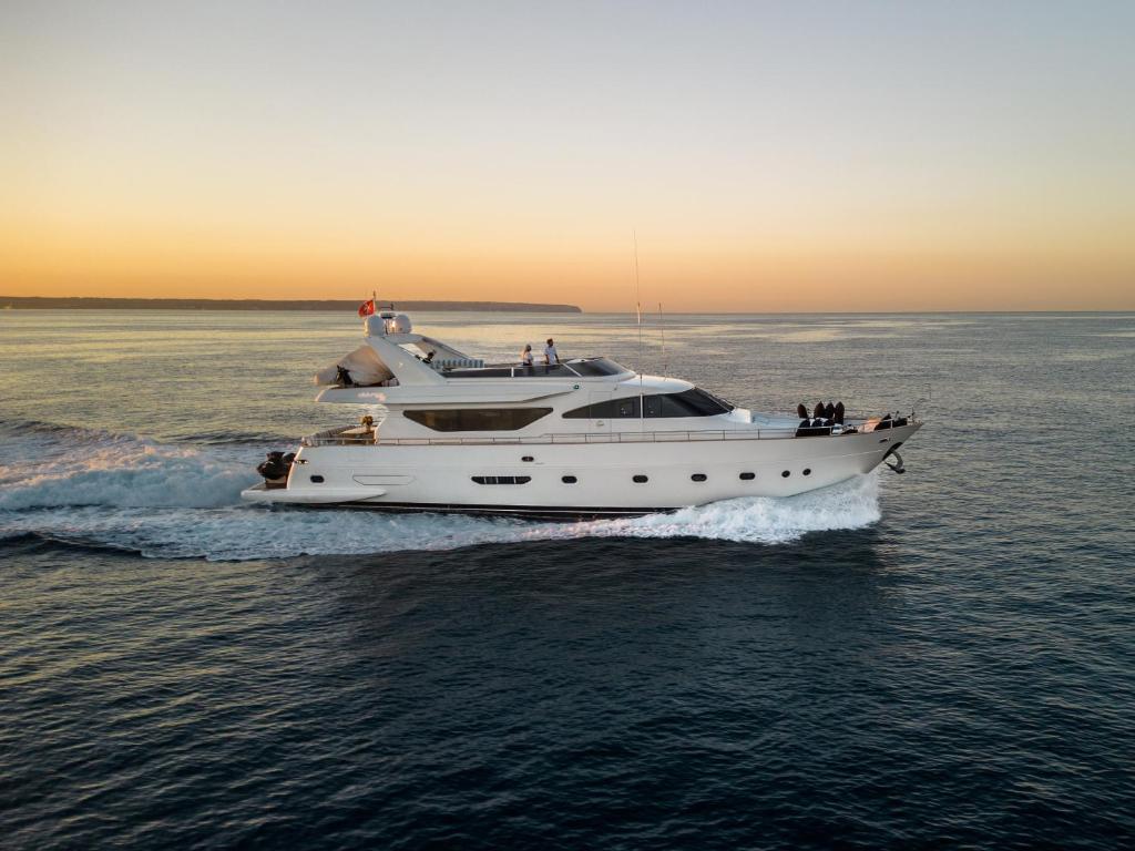 een wit jacht in het water bij zonsondergang bij EssoEss Boat - Five Star - Exclusive use in Palma de Mallorca