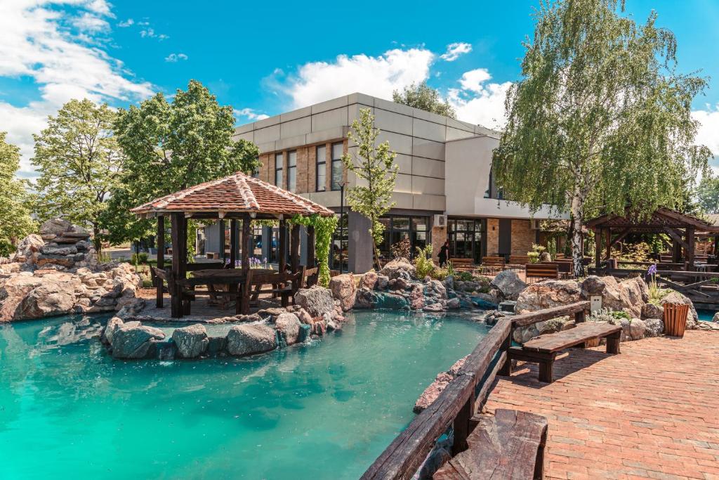 a pool of water with benches in front of a building at Apostolovic Plus in Leskovac