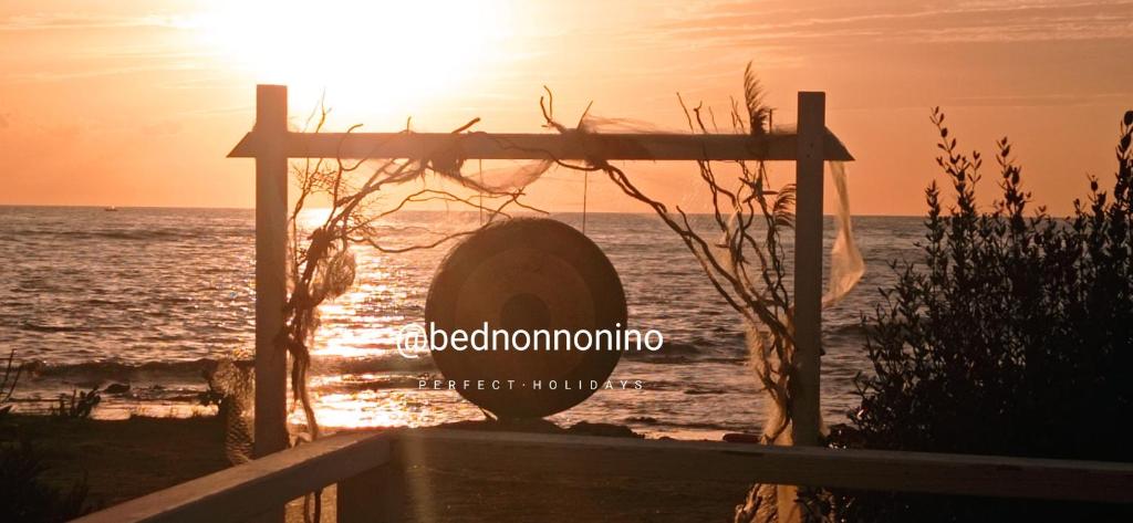 un tramonto sulla spiaggia con il sole che tramonta sull'oceano di Bed Nonnonino a Porto Cesareo