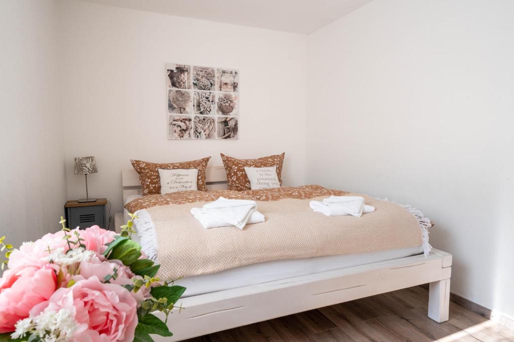 Schlafzimmer mit einem Bett mit einem Blumenstrauß in der Unterkunft Allgäutraum Ferienwohnung Nr. 9 in Kempten