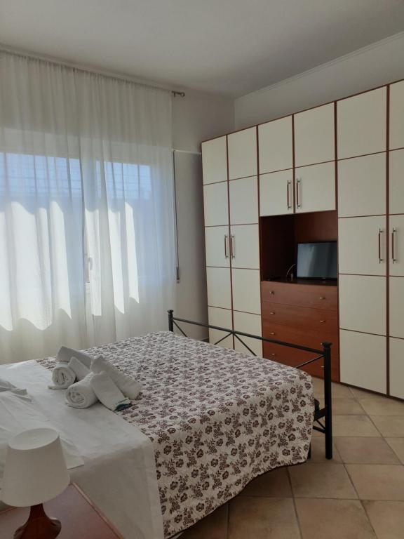 una camera da letto con un letto, una cassettiera e una TV di IL MARE DI ROMA APARTMENT a Lido di Ostia