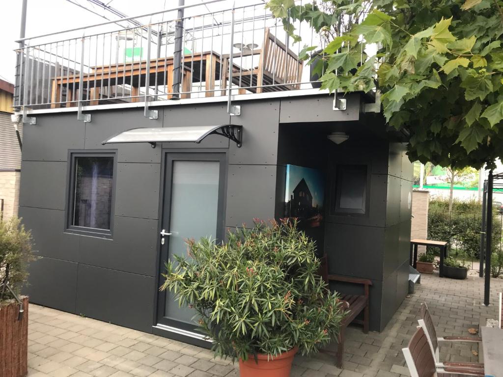 a gray building with a door and some plants at Tiny House Black Pearl in Tettnang