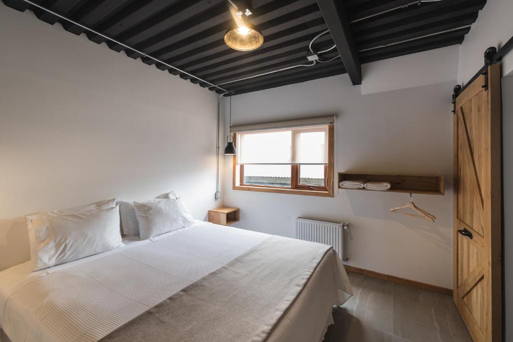 a bedroom with a large bed and a window at Hotel Big Sur in Puerto Natales