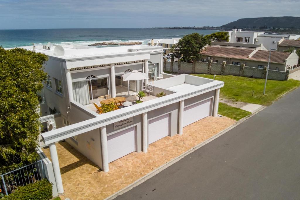 an aerial view of a house with the ocean in the background at Hermanus Beachfront Lodge - Solar Power in Hermanus