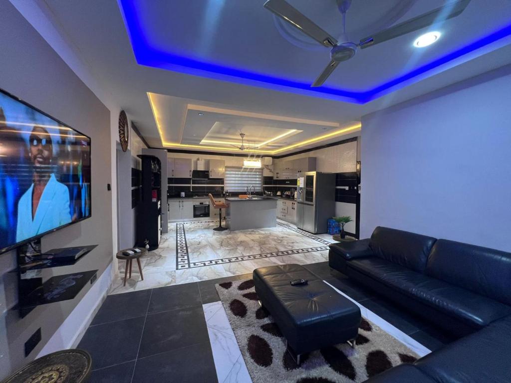 - un salon avec un canapé et une télévision dans l'établissement T-Roys Apartments, à Accra
