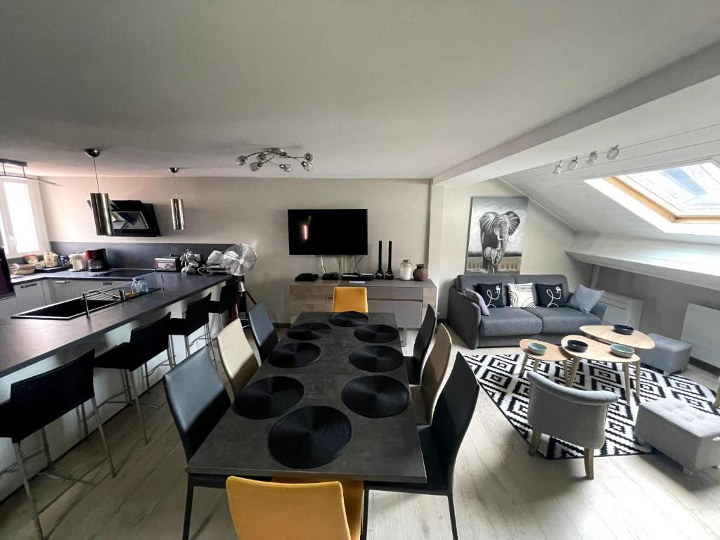 a kitchen and living room with a table and chairs at Le 3 de Coeur Annecy in Annecy