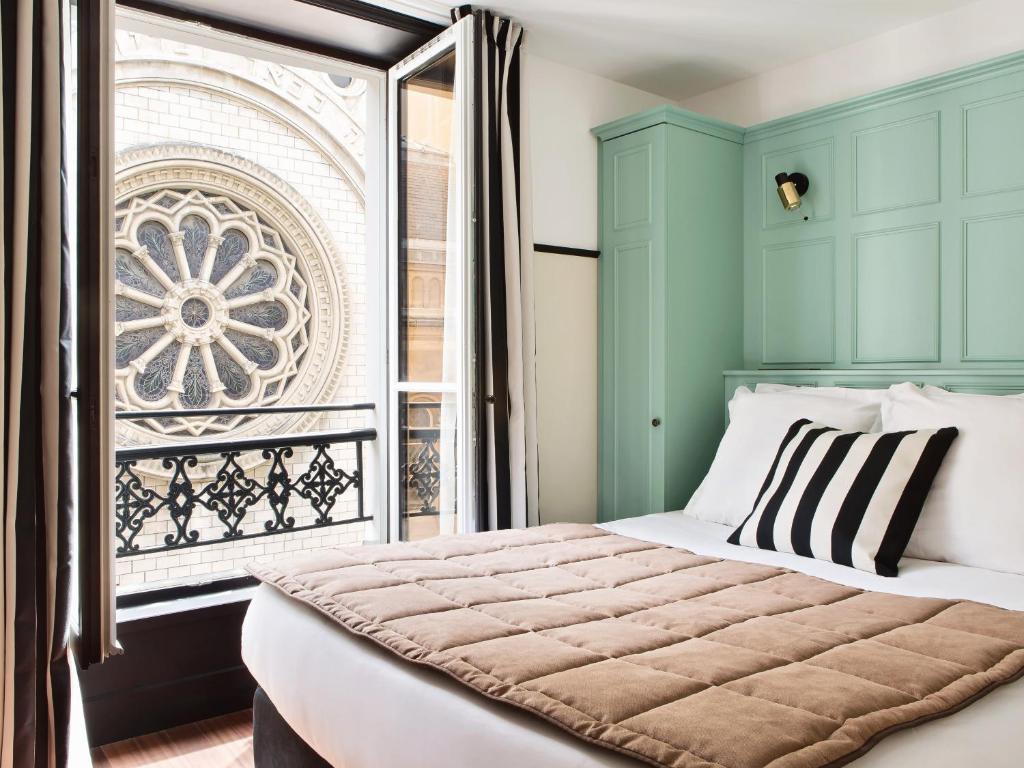 een slaapkamer met een bed en een raam bij New Hotel Lafayette in Parijs